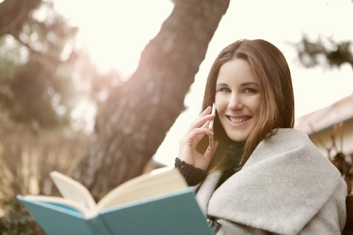 Woman in Gray Sweater Sitting Under the Three Trunks