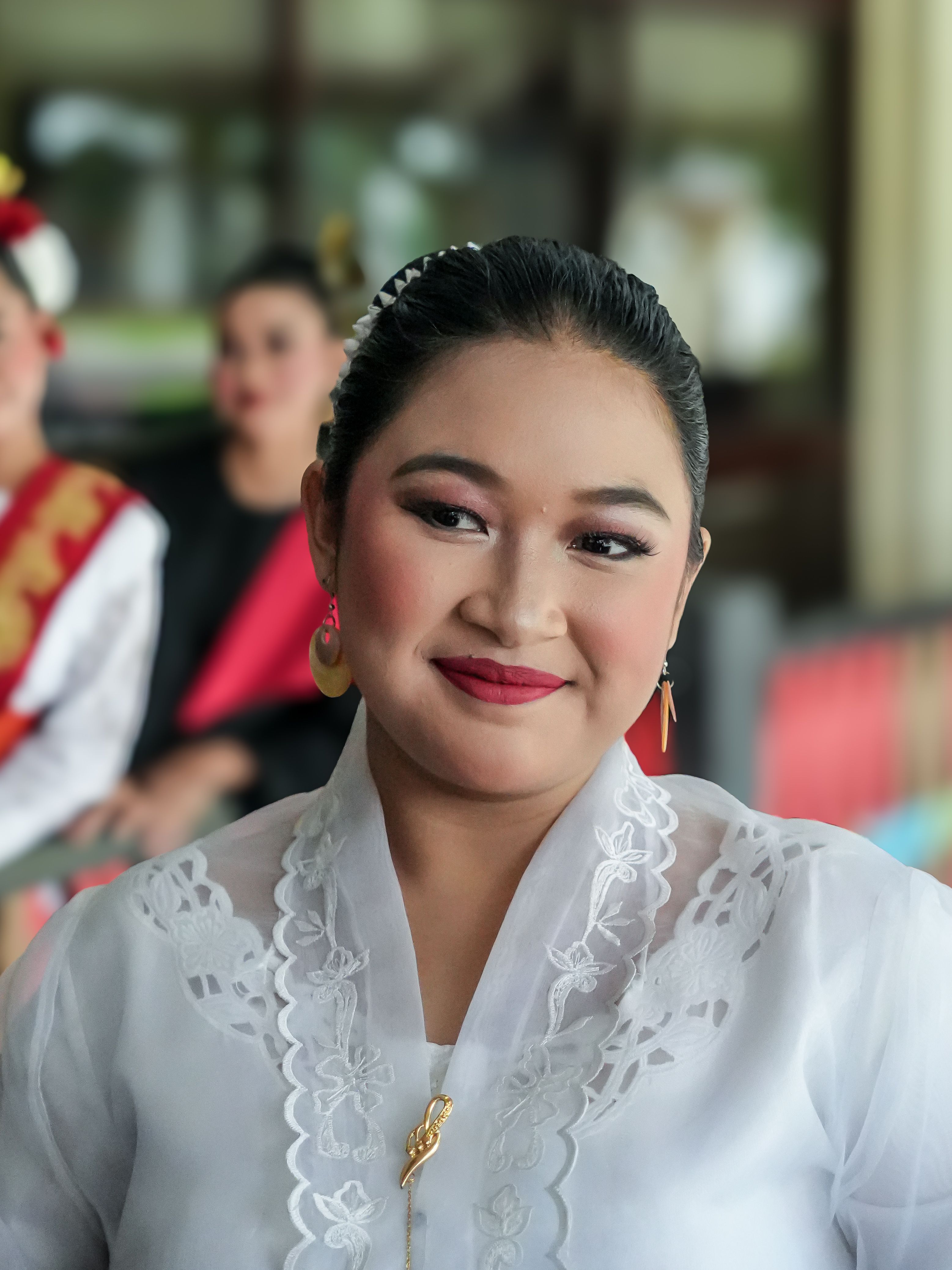 Close-up of a smiling woman in traditional Indonesian attire, Jakarta.