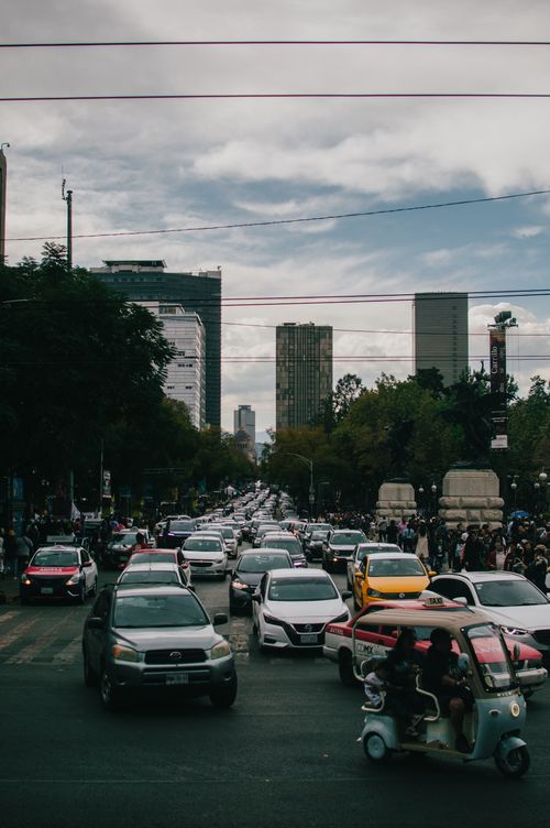 Free A busy city street in Ciudad de México with traffic and people under a cloudy sky. Stock Photo