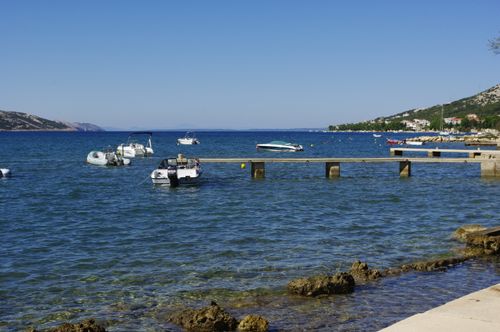 Free Calm sea with boats at Stara Novalja, showcasing Croatia's clear waters and tranquil landscapes. Stock Photo
