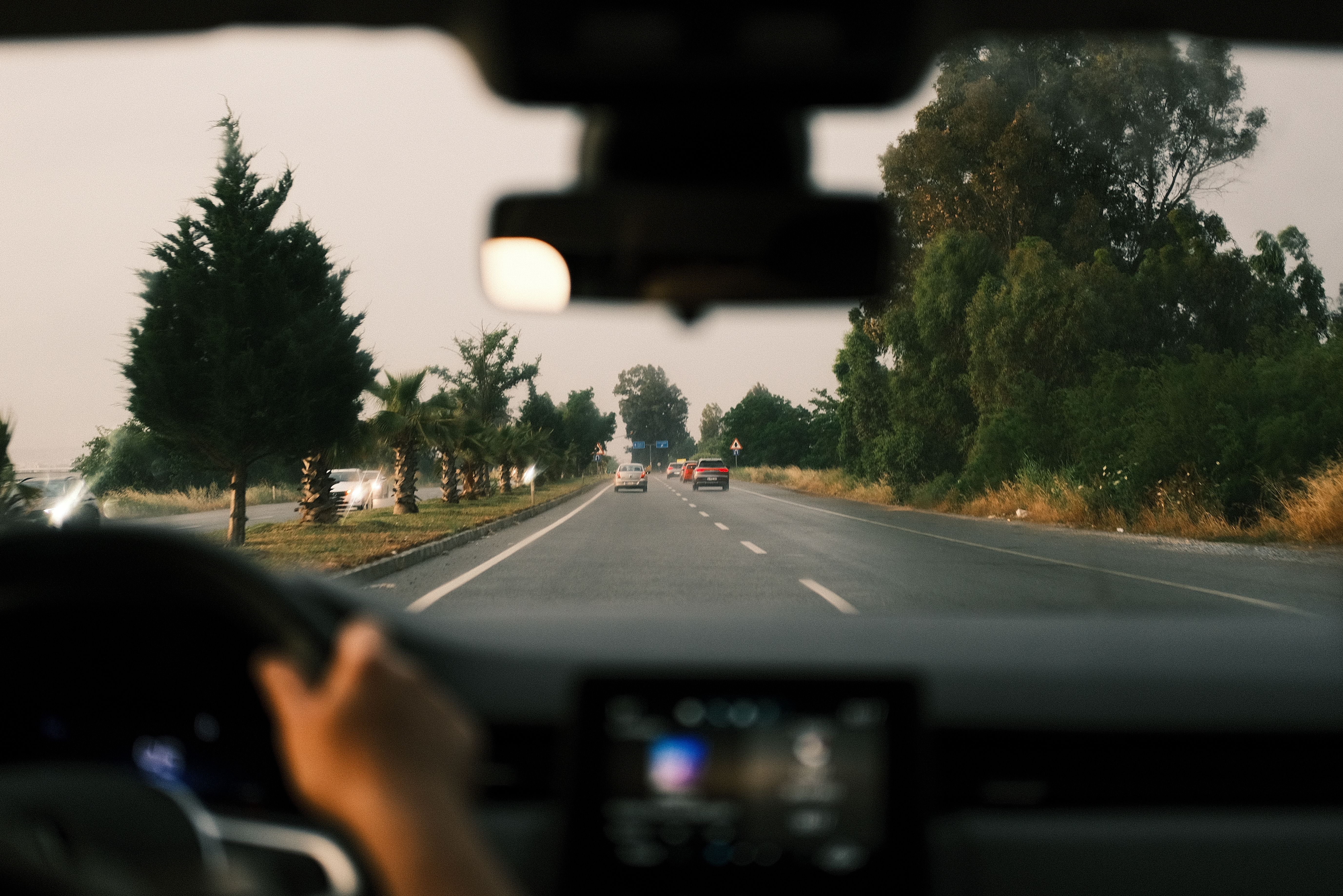 Hands holding auto insurance policy documents with a car key nearby