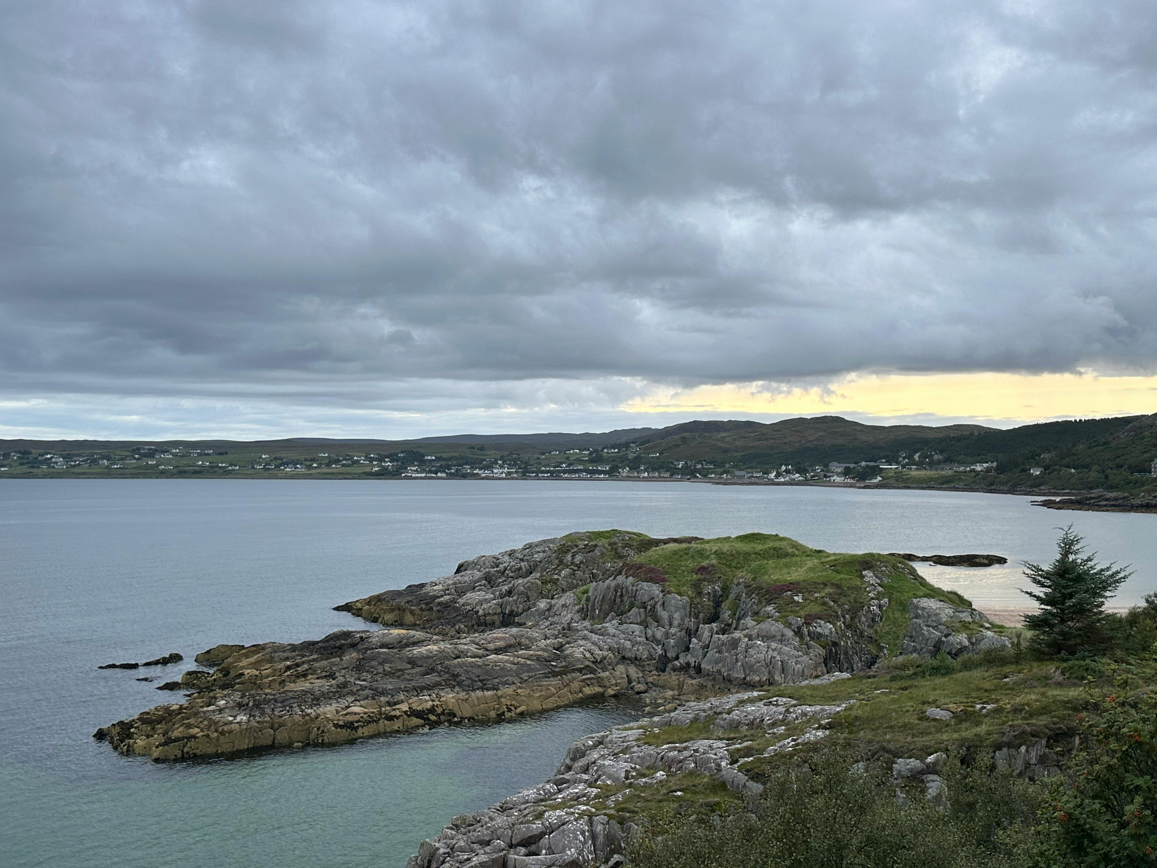 Picturesque view of Gairloch's rocky coastline under a cloudy sky, perfect for travel enthusiasts.