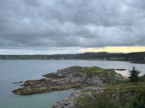 Picturesque view of Gairloch's rocky coastline under a cloudy sky, perfect for travel enthusiasts.