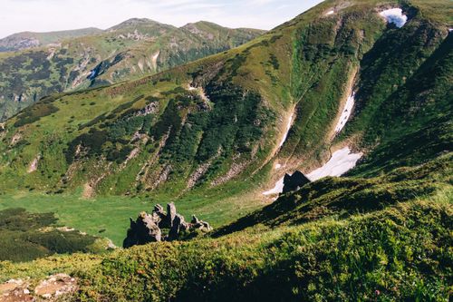Free Breathtaking view of lush green mountains and valleys under a clear sky. Stock Photo