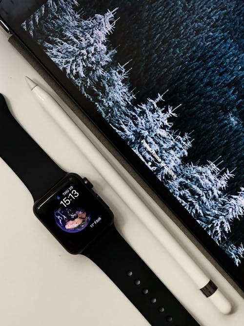 스타일러스 펜 옆에있는 검은 색 Apple Watch의 평면 배치 사진