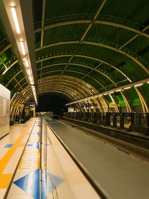 Free Empty subway station platform with unique green arched ceiling at night. Stock Photo
