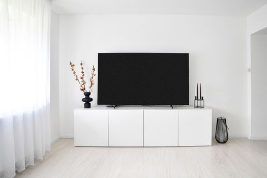 A sleek and minimalist Scandinavian living room with white decor and electronics.. sleek, minimalist, scandinavian