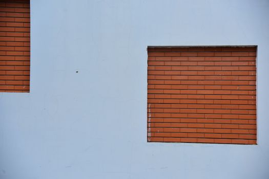 A minimalist wall design featuring red brick inlays on a blank surface, ideal for architectural concepts.