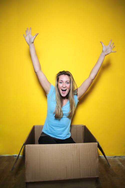 Free Woman in Blue Shirt Raising Her Hands Stock Photo