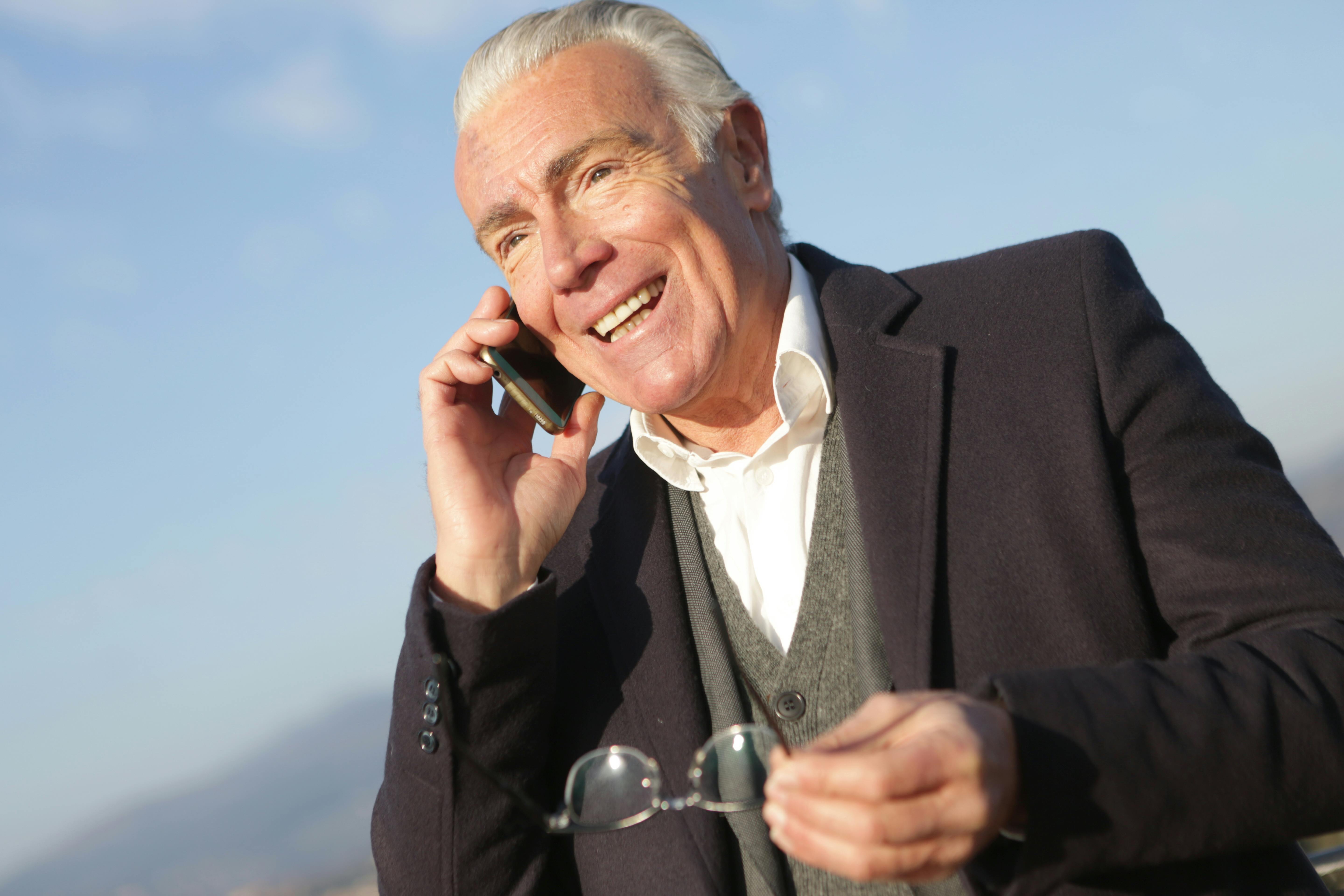 mature businessman having conversation on smartphone in city