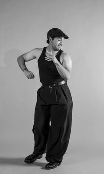 Black and white photo of a male dancer in vintage attire, mid-motion, showcasing energy.