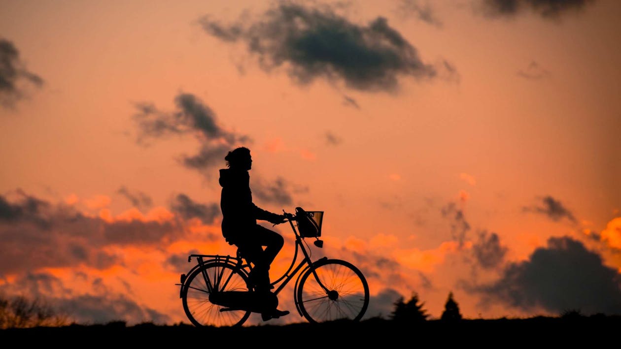 gratis Silhouet Van Een Persoon Die Op Een Fiets Rijdt Tijdens Zonsondergang Stockfoto