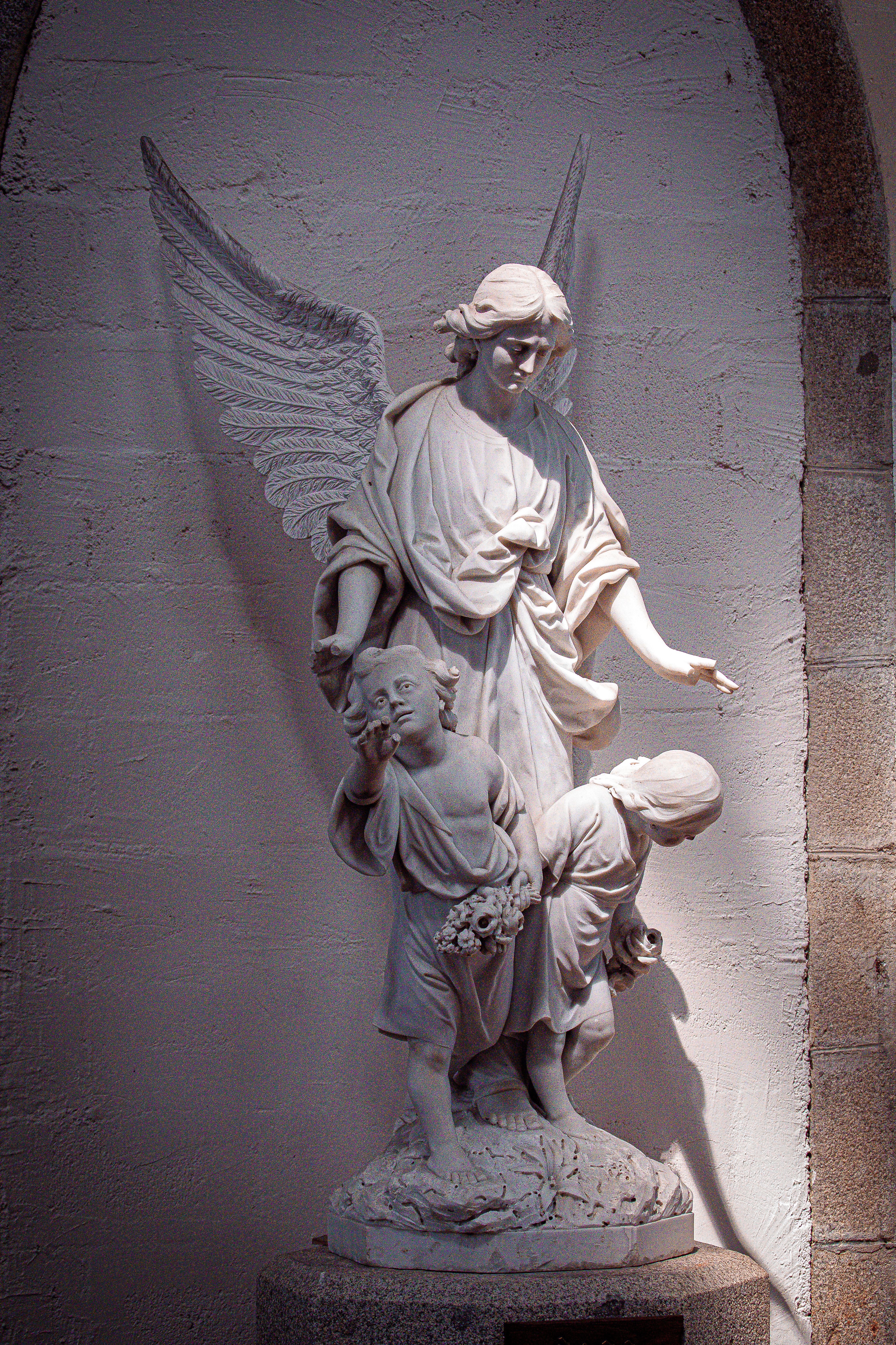 Beautiful stone angel statue with children inside a Normandy church.