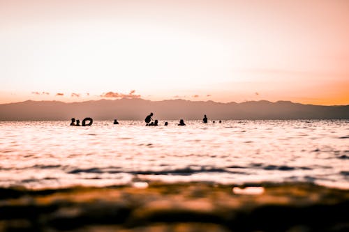 免費 人們在日落海灘上的剪影 圖庫相片