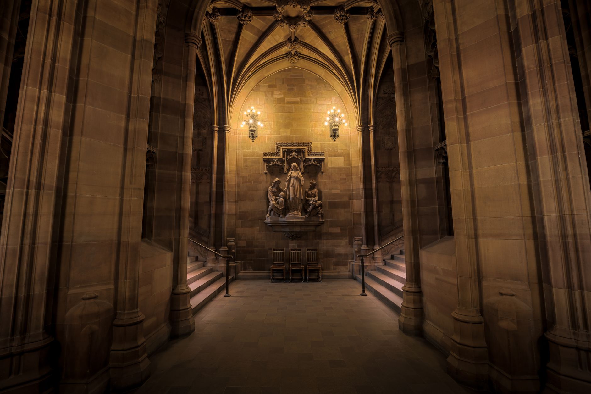 Historic Gothic interior of the John Rylands Library in Manchester, with soaring arched ceilings and stained glass