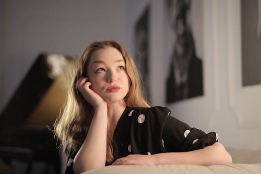 一位穿着圆点连衣裙的女人坐在室内，陷入沉思