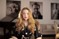 一位优雅的金发女子坐在室内，穿着波尔卡圆点服装，坐在一个时尚的房间里