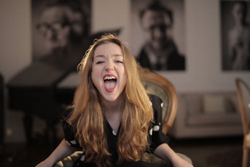 Woman in Black Polka Dots Shirt Sitting on Chair