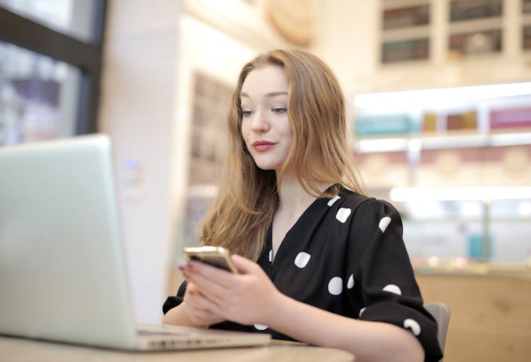 Woman In Black And White Polka Dot Dress Using Portable Computer