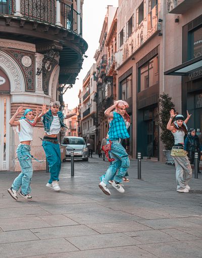 Dancers mid-jump on a city street — JOSE BARON on Pexels