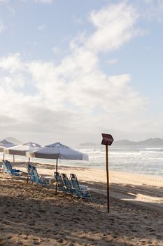 Relaxing beach scene with sun loungers and umbrellas on a sandy shore in São Paulo, Brazil.