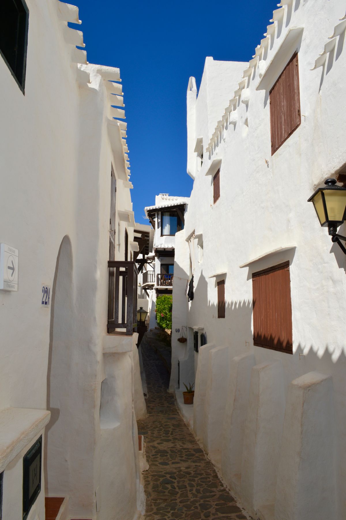 A narrow whitewashed alley with blue sky view in Dalt Vila, Ibiza