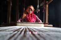 Woman weaving on a loom in Bukittinggi, West Sumatra. Traditional craftsmanship and culture.