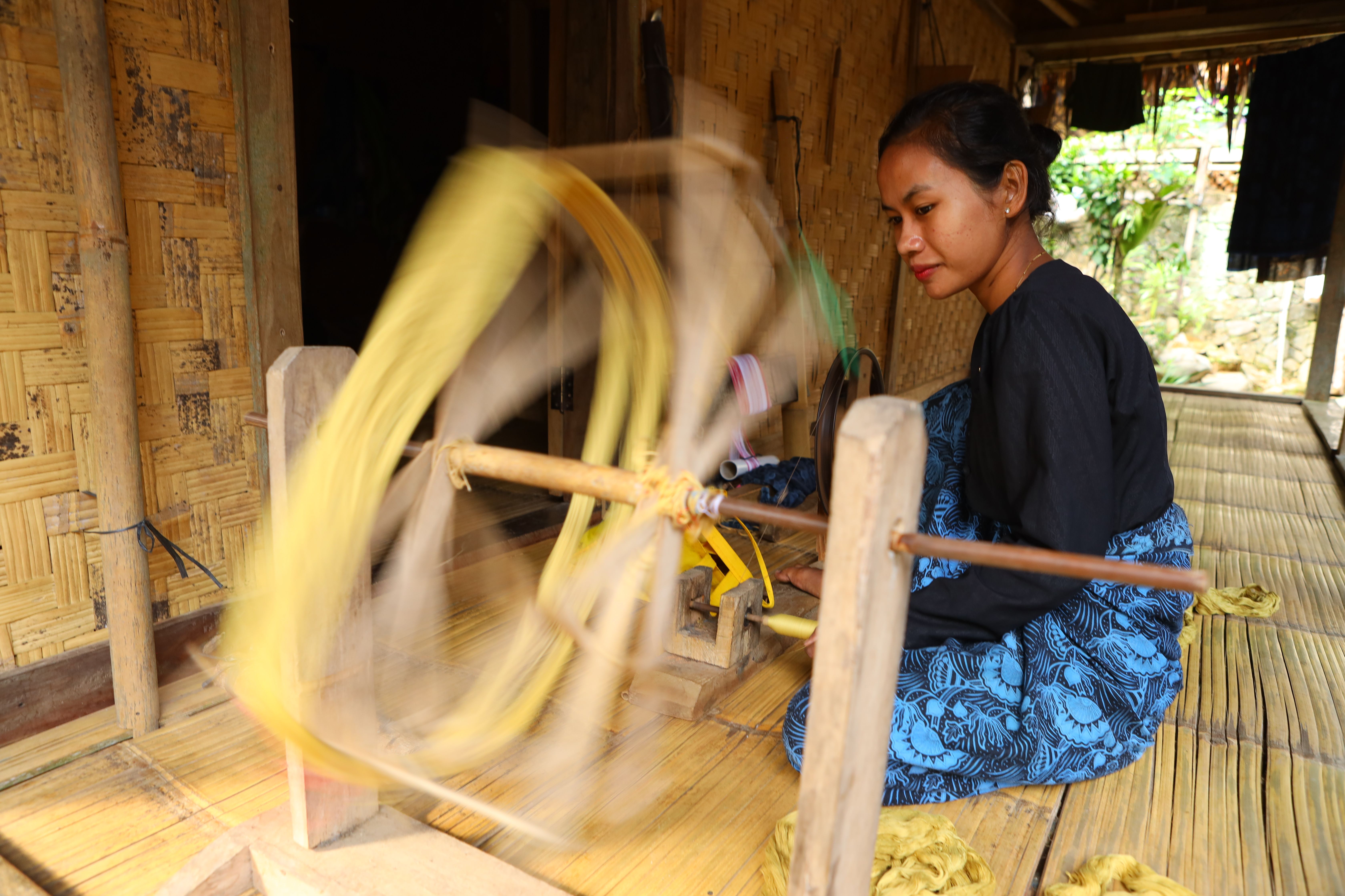 Woman weaving traditional fabric in Banten, Indonesia, showcasing cultural craftsmanship.