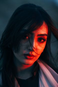 Close-up portrait of a woman with striking lighting, captured at night.