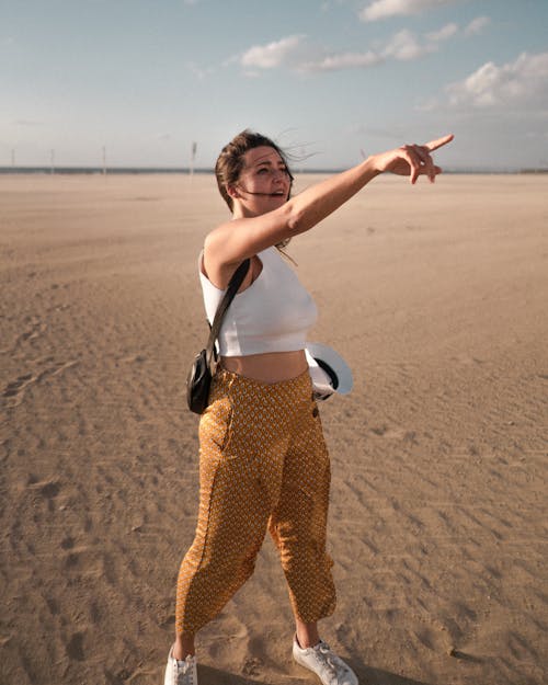 Woman In White Tank Top Standing On The Sand