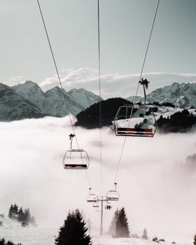 缆车滑过迷雾笼罩的山地，白雪皑皑的山峰和广阔的冬日景象逐渐显露出来