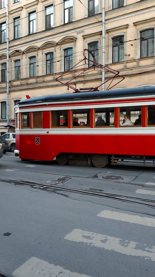 Free Red and White Tram on Road Near Building Stock Photo