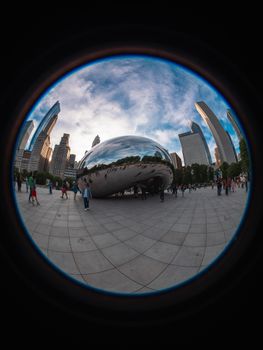 Fisheye lens captures Cloud Gate sculpture in Chicago with city skyline.