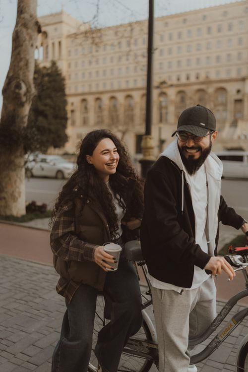 Free Smiling couple on a bicycle enjoying a leisurely day outdoors Stock Photo