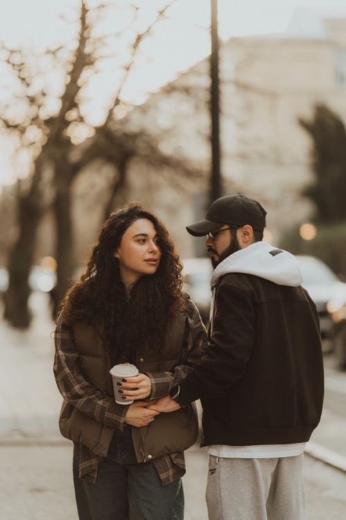 Free Couple enjoying a peaceful walk on a city street during a calm day. Stock Photo