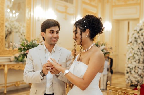 Free A bride and groom exchange rings during a luxurious indoor wedding ceremony. Stock Photo