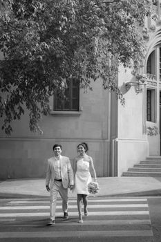 A couple shares a joyful moment walking hand-in-hand on their wedding day.