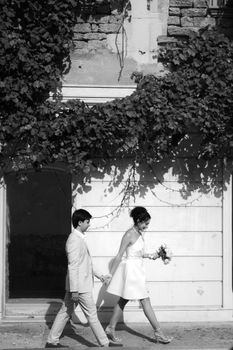 Elegant black and white portrait of a couple walking on their wedding day.