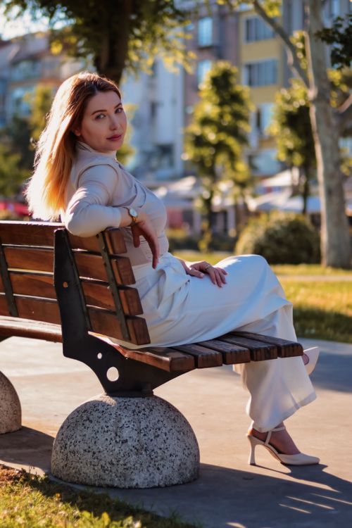 Woman Relaxing on Park Bench in Sunlight · Free Stock Photo