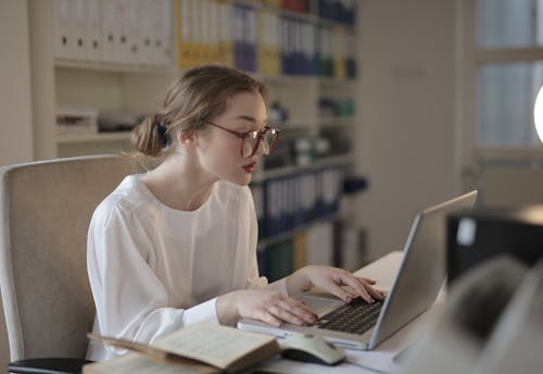 Free Woman In White Dress Shirt Using A Laptop Stock Photo