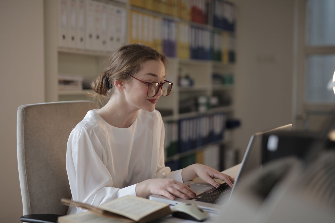 Candidate working at a laptop in a warm office — photo by Andrea Piacquadio on Pexels