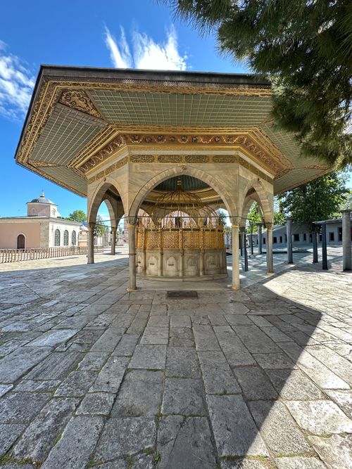 Free View of ornate Ottoman-style structure with decorative roof under a clear blue sky. Stock Photo