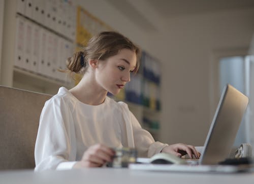 бесплатная Сосредоточенная женщина, смотрящая на ноутбук Стоковое фото