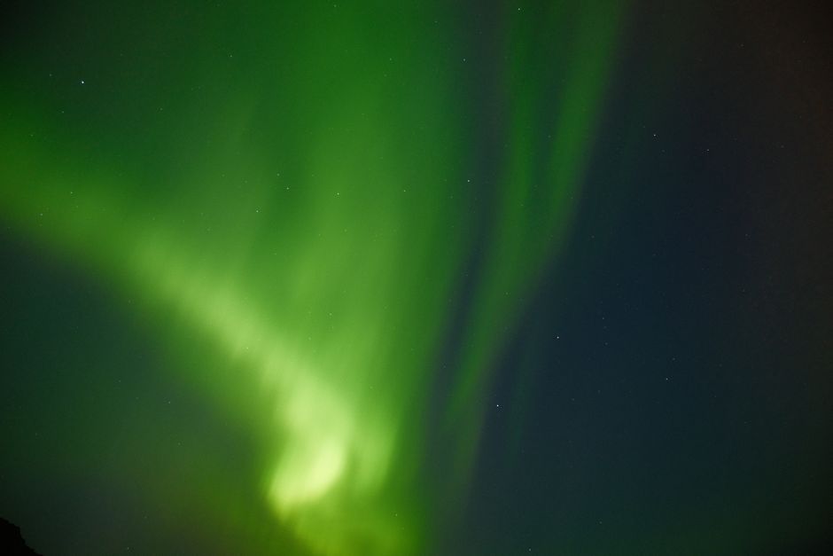 Captivating view of the Northern Lights dancing across Iceland's night sky, showcasing nature's vivid green hues.