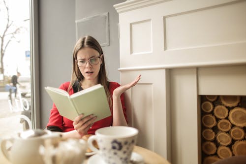 Free Woman In Red Long Sleeve Reading A Book Stock Photo