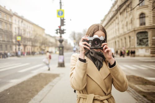 Person In Brown Coat Holding An Old Camera