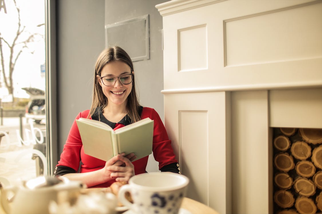 Woman In Red Long Sleeve Shirt Reading A Book