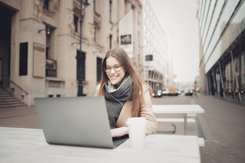 Woman In Brown Coat Using A Laptop