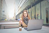 都市里，有信用卡的少妇用膝上型计算机进行网上购物