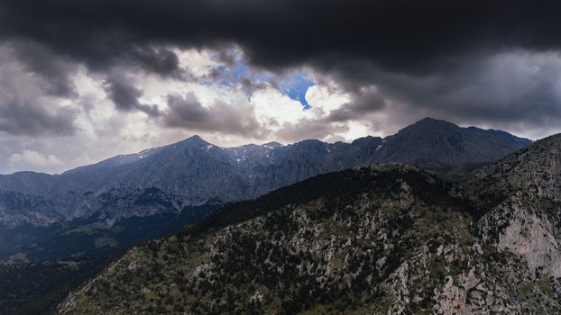 A striking view of a mountainous landscape in Delphi, Greece under dramatic clouds.